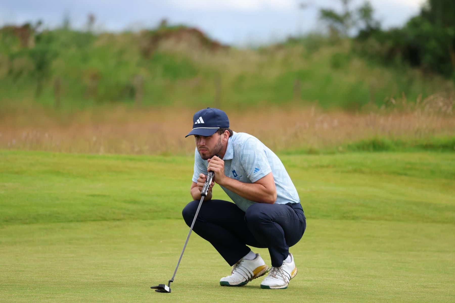 David Howard crouched on the green reading a putt